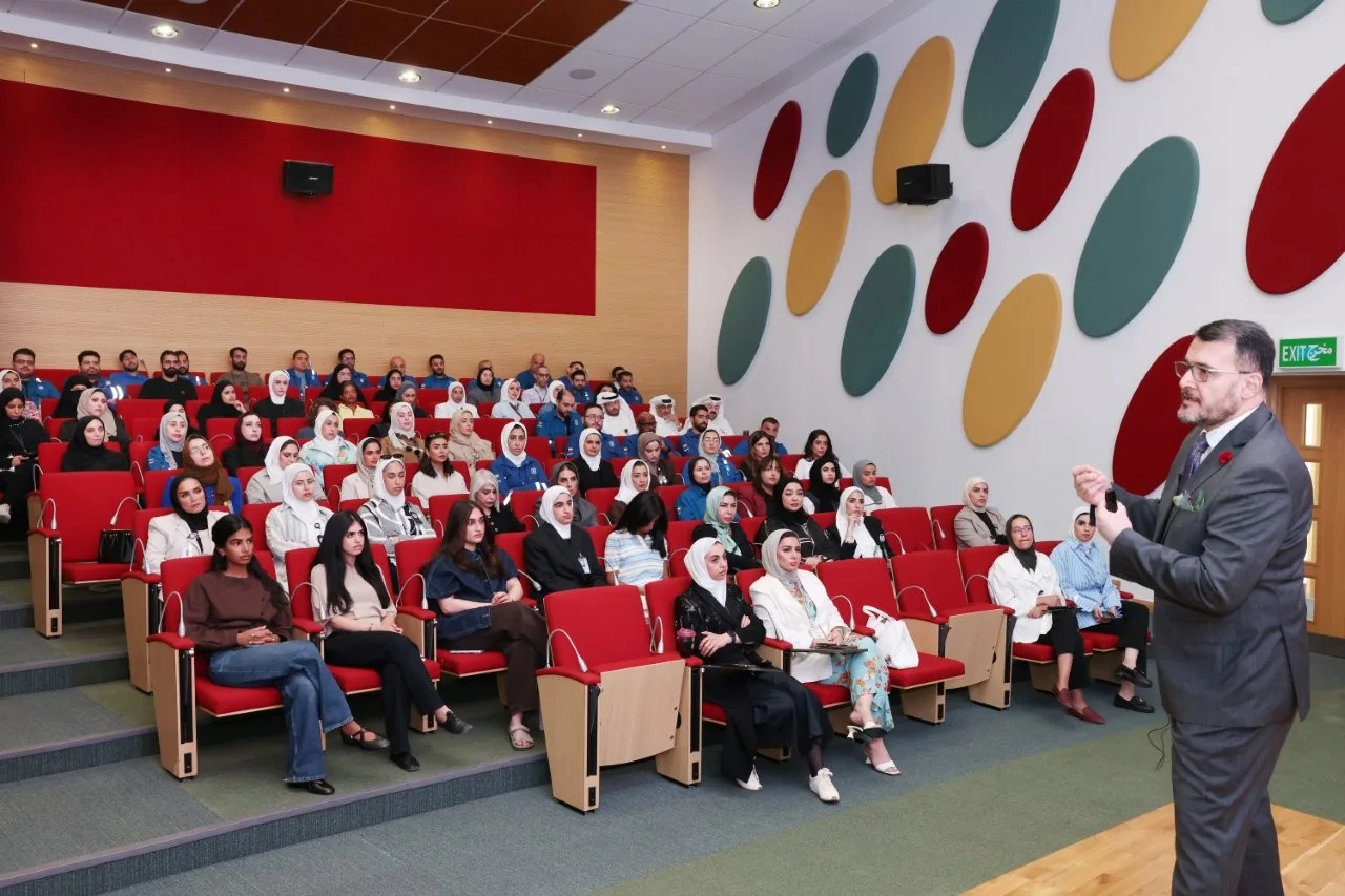 Dr. Nizar Baidoun on stage, delivering a business ethics session to a full auditorium of Kuwait Oil Company staff
